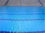 Trembling surface of an Olympic size swimming pool in empty sport arena