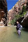 Woman hiking the Narrows in Zion National Park