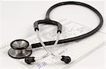 Stethoscope lying on a medical report on a white desk