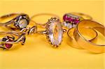 Gold jewellery rings on yellow light bacground