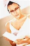 Young pretty women reading a book. Wearing glasses.