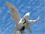 detail of winged angel statue against blue sky