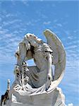 detail of winged angel statue against blue sky