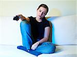 Female in blue jeans sitting on the sofa and watching tv