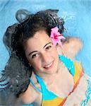 Pretty teen girl with a fower in a pool