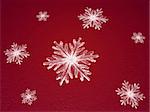 crystal snowflakes over red background with feather center