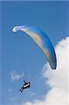 Paraglider in a blue sky with white clouds