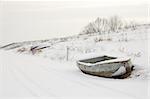 Boat in snow on shore, with visible trail