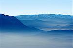View of a valley and blue mountains in the fog