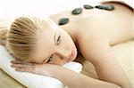 Young blond woman getting lastone treatment at spa