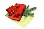 Two red gift boxes with Christmas postal card and branch of fir-tree