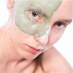 Nude woman model wearing a partial clay mask