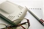 modem, notebook, pen and glasses on a light background