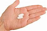 Two white pills on a hand isolated on white background