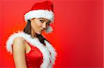 Portrait of beautiful brunette woman wearing sexy santa claus clothes on red background