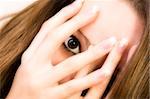 Studio portrait of pretty brunette looking through her fingers