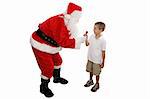 Cute little boy receiving a lolipop from Santa.  Full body isolated.