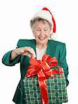 A senior woman anticipating opening a big Christmas gift.  Isolated on white.