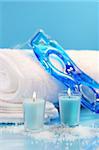 Blue spa relaxation with candles and towels