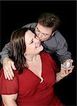 Beautiful plus sized model whose boyfriend is proposing to her.  Black background.