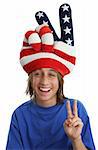 An immigrant child wearing a USA patriotic hat and giving a peace sign.