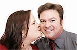 Attractive guy surprised by a kiss from his pretty girlfriend.  White background.  Perfect for Valentines Day.