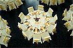 Table setting with golden plates and heart shapes on napkins plus scattered fresh rose petals for a wedding or romantic dinner event