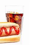 A hot dog and soda glass, reflected on white background. Shallow DOF