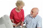 An attractive retired couple surfing the net together. Isolated