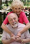 A happy senior couple embracing outdoors.  They are still in love after many years together.