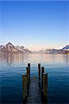 Empty dock in calm lake with mountains in the horizon. Buochs, Switzerland.