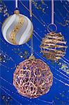 Festive Christmas hanging balls composition on blue decorative winter background with sparkles and stars
