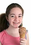 A cute teen girl with braces holding a chocolate ice cream cone.
