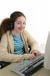 A teen girl doing her homework online and listening to headphones.