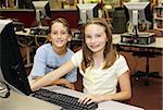 A boy and girl doing research in the school computer lab.