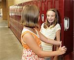 Two middle school students chatting at their lockers.