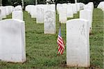 a soldiers grave with an american flag, in a military graveyard