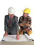 an engineer explaining the blueprints to the construction foreman - isolated
