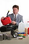 A weatherman displaying disaster supplies and holding a gas can.