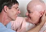 A cancer patient and her husband sharing a tender moment of affection.