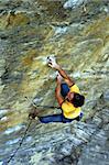 Strong free climber climbing a hard wall