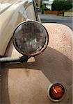 Detail of an old brown car with two headlights