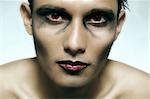 Studio portrait of mixed race young man with extreme make-up