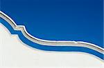 Top of a garnished curved wall adorned with a blue strip