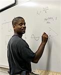 A handsome african-american student at the board doing trigonometry.