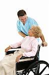 Doctor or male nurse caring for a senior woman in a wheelchair.  Isolated on white.