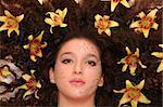 Young girl with beautiful rhinestone makeup and lilies in her hair