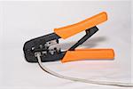 RJ-45, RJ-11 crimping tool with cable on white background.
