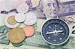 Compass on canadian dollar bill and coins