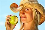 Healthy young woman eating a geen apple